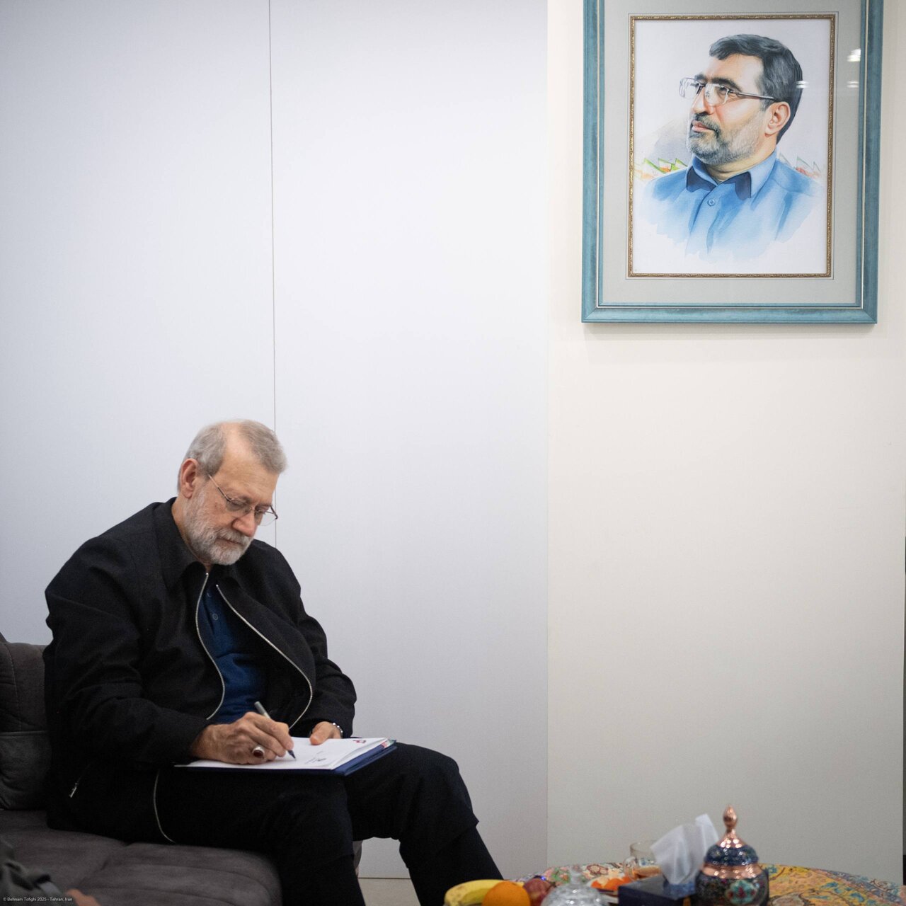 دیدار علی لاریجانی با خانواده شهیدان حاجی‌زاده و محمود باقری/ عکس خاص لاریجانی حین تماشای عکس های سرداران شهید جنگ 12 روزه + تصاویر