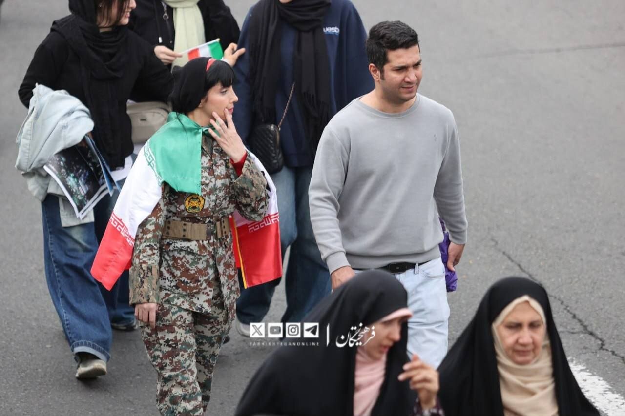 این خانم با لباس ارتشی در راهپیمایی 22 بهمن سوژه عکاس‌ها شد + تصویر